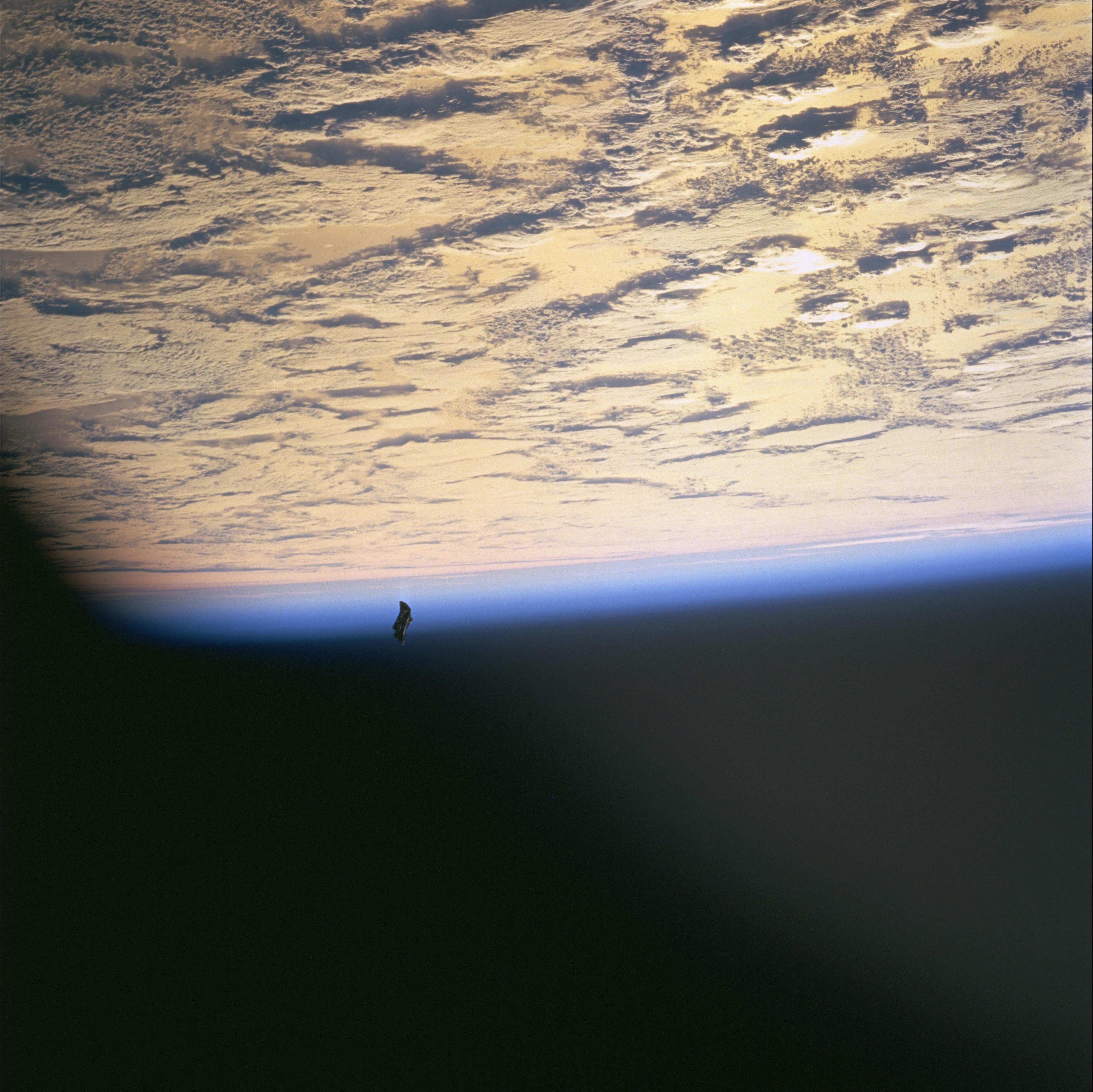 NASA STS-88 still STS088-724-66 showing a dark irregular free-flying object near Earth - identified as a lost thermal cover, public-domain U.S. government work.
