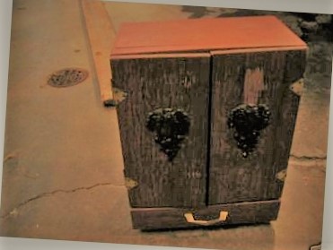 Front view of a wooden Dybbuk Box–style cabinet, Wikimedia Commons photograph.
