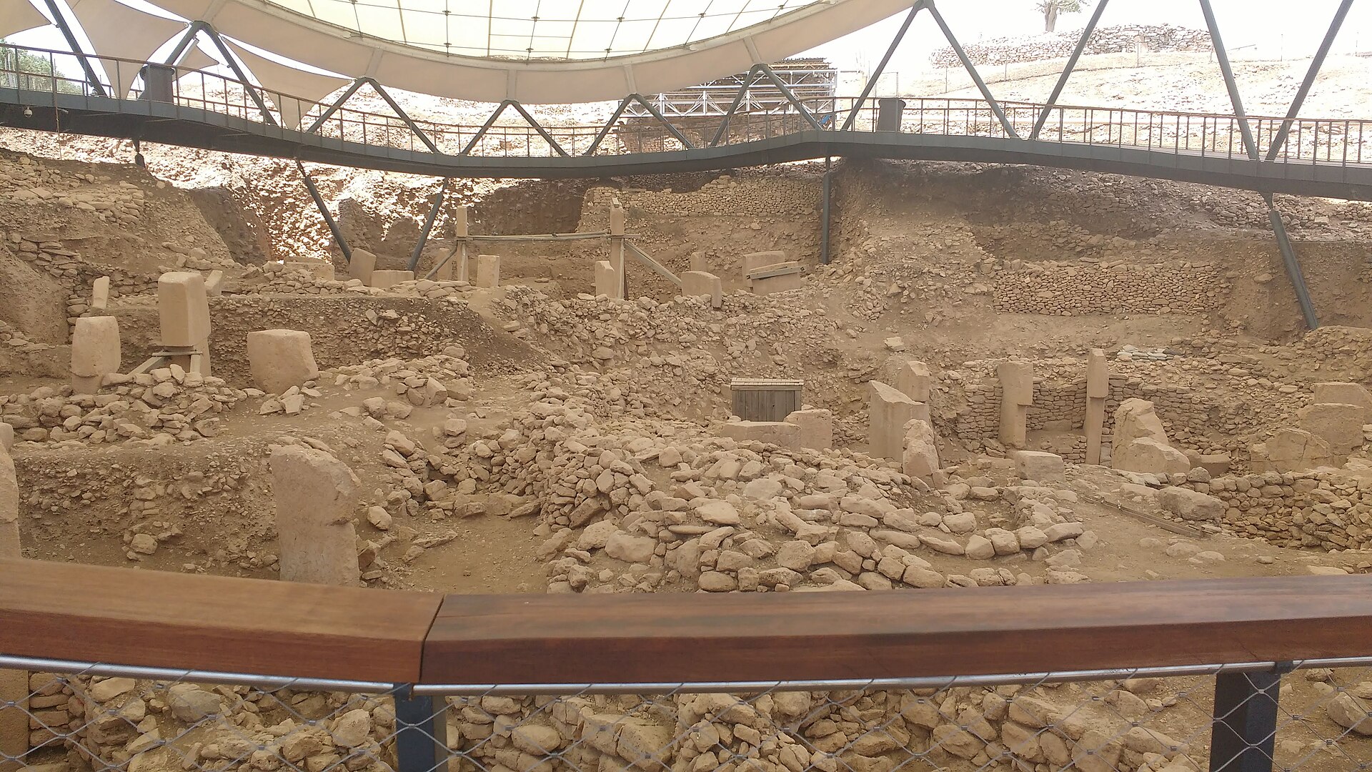 Enclosure view with carved T-pillars at Göbekli Tepe under the site canopy.