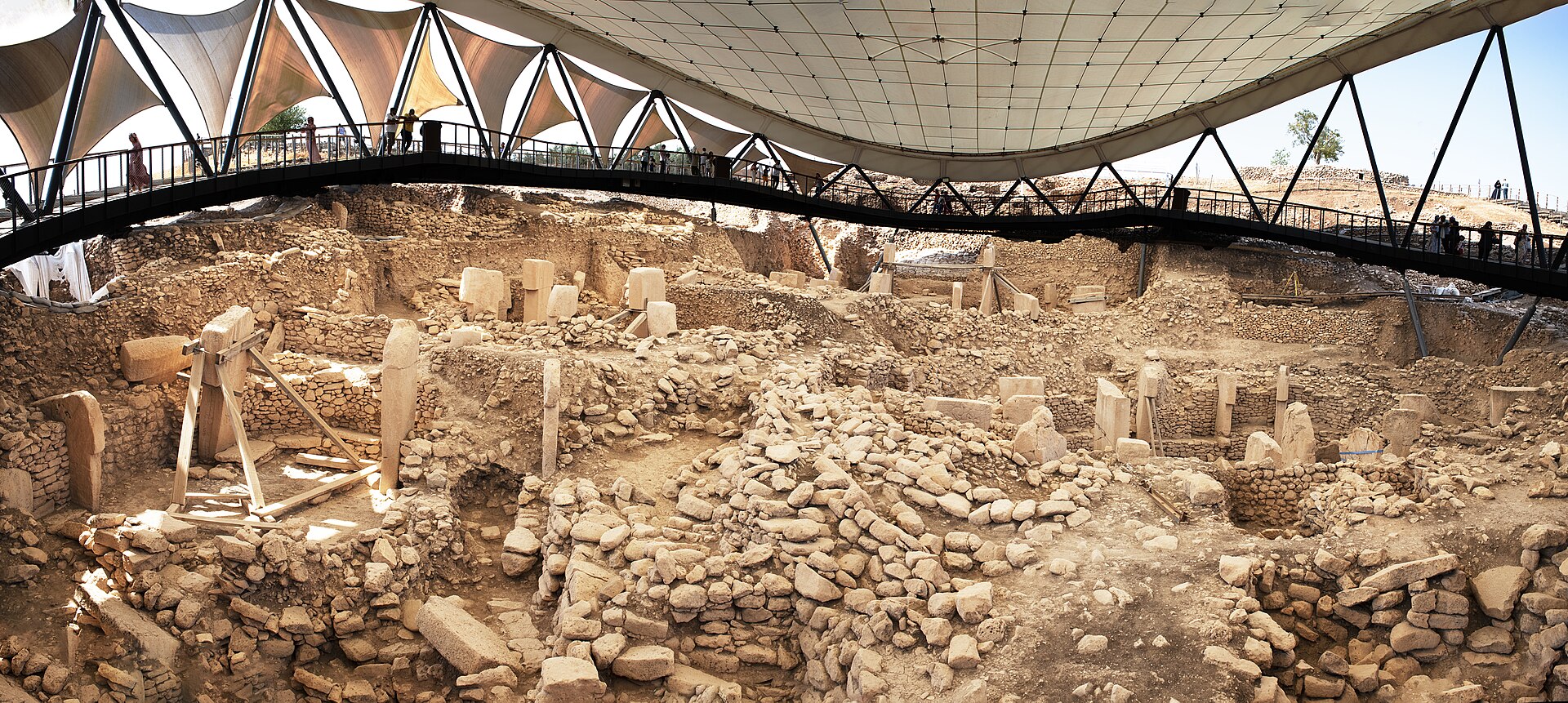 Wide panorama of excavated Göbekli Tepe enclosures and surrounding plateau.